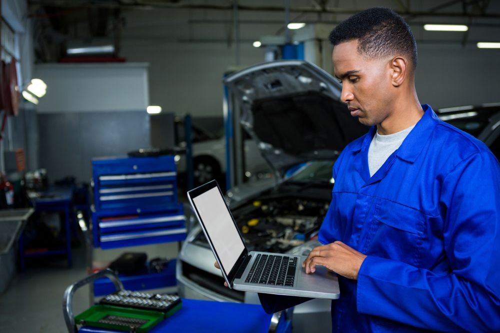 Shop manager reviewing a repair order on a tablet in a fleet maintenance bay